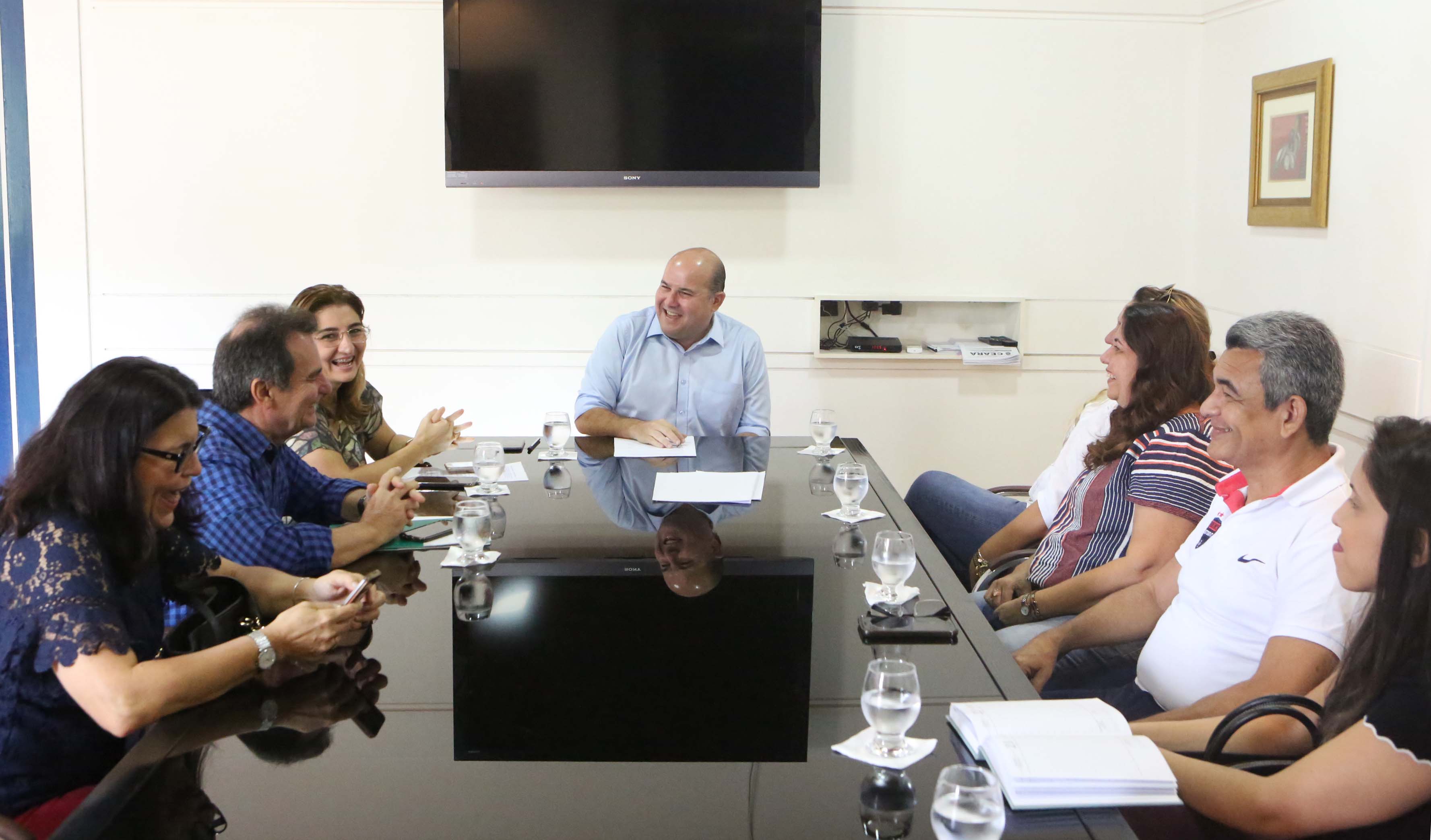 um grupo de pessoas ao redor de uma mesa de reunião